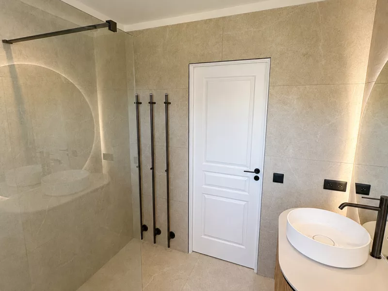 Douche à l'italienne avec barres chauffantes noires et meuble vasque en vis-à-vis, rénovation salle de bain à Bandol.