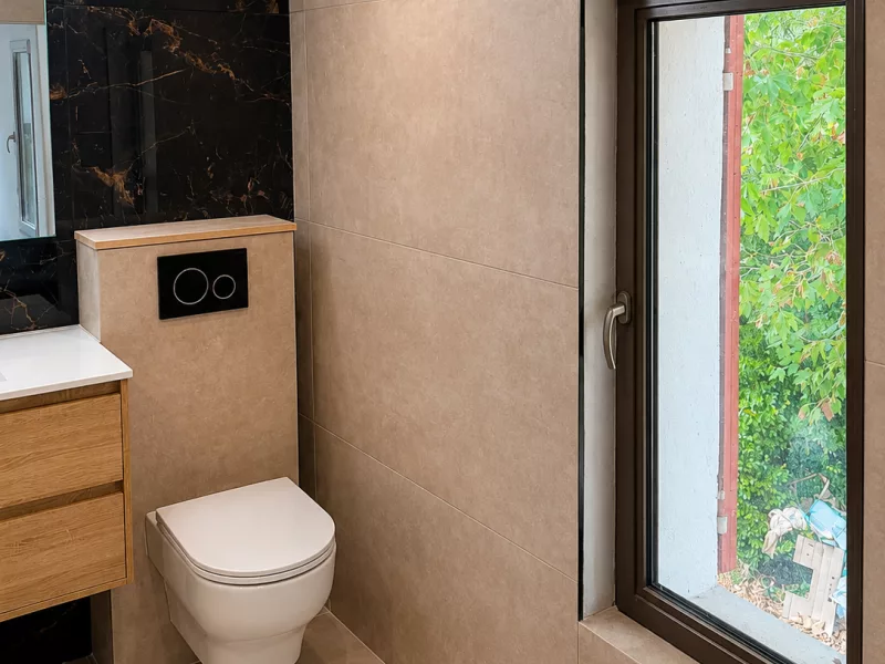 WC suspendu avec plaque de commande noire et fenêtre neuve, rénovation salle de bain à Aix-en-Provence.