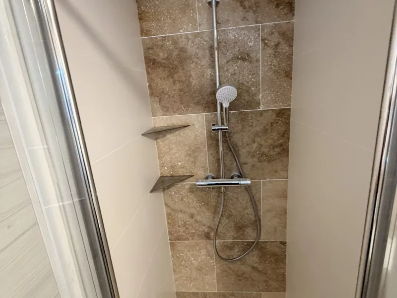 Colonne de douche thermostatique avec tête de pluie et étagères d'angle.