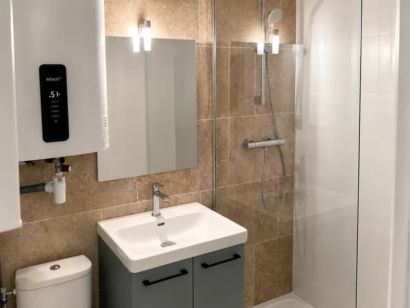 Douche à l'italienne en travertin 40x60 avec paroi vitrée fixe, rénovation salle de bain à Bormes-les-Mimosas.