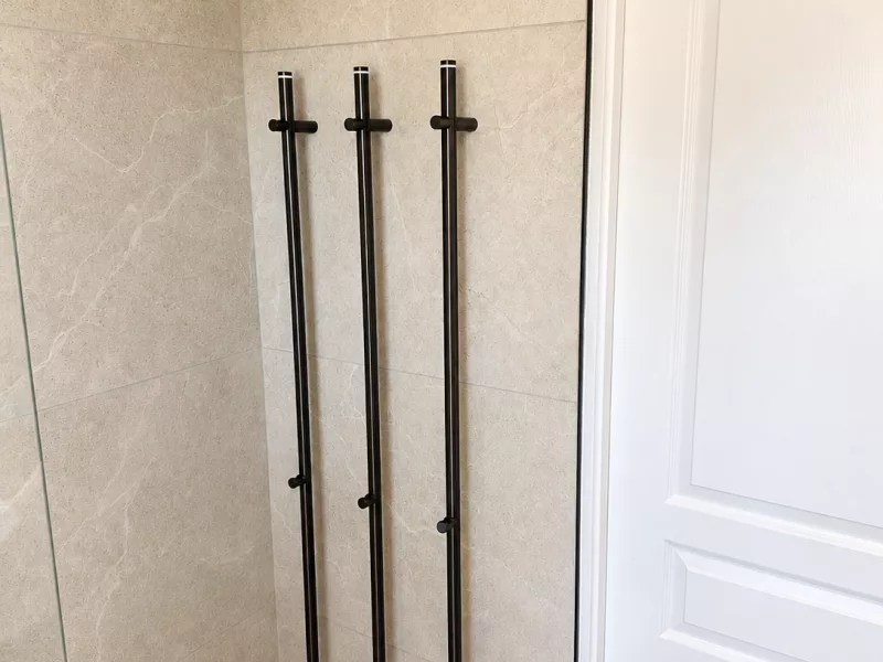 Barres chauffantes noires (chauffe-serviette) installées dans la salle de bain rénovée à Bandol.